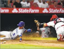  ?? Ashley Landis Associated Press ?? THE ROYALS’ Nicky Lopez is tagged out at the plate by Angels catcher Kurt Suzuki on a ninth-inning fielder’s choice. Lopez had an RBI double in the seventh.