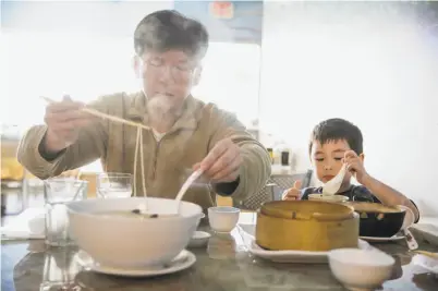  ?? Gabrielle Lurie / The Chronicle ?? A father-and-son dinner at Noodle Shanghai in San Mateo.