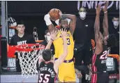  ?? JOHN RAOUX — THE ASSOCIATED PRESS ?? Lakers forward LeBron James passes between Heat guard Duncan Robinson, left, and forward Jimmy Butler in Game 4 of the NBA Finals on Tuesday in Lake Buena Vista, Fla.