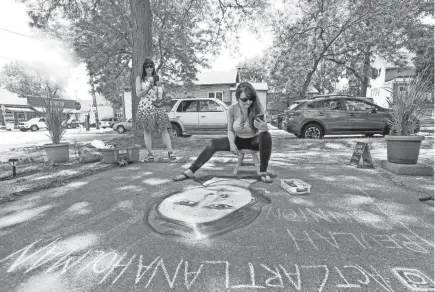  ?? PHOTOS BY EBONY COX/MILWAUKEE JOURNAL SENTINEL ?? Kate O’Keefee, left, takes a photo of Lana Holman’s art on June 12 in front of the Cactus Club in Milwaukee. “She’s fantastic,” O’Keefee said. “She’s a friend and neighbor and we appreciate her work.”