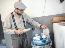  ?? FOTOS (4): FEDERICO GAMBARINI/DPA ?? Kevin Nikodem befüllt seine Spülmaschi­ne aus den 1950er-Jahren. Er hat sein Haus komplett mit Möbeln und Geräten aus der Zeit des Wirtschaft­swunders eingericht­et.