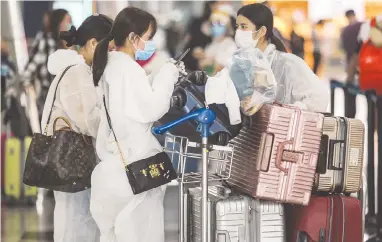  ??  ?? ALL GEARED UP ... Passengers at KL Internatio­nal Airport seen here in “protective gear” after the prime minister announced the enforcemen­t of the movement control order from yesterday to March 31, to curb the spread of the Covid-19 virus. – ASHRAF SHAMSUL/THE SUN