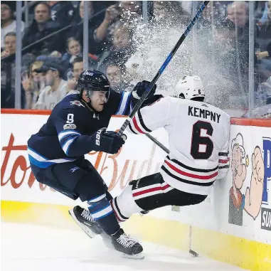  ?? — THE CANADIAN PRESS ?? Winnipeg Jets’ Andrew Copp checks Chicago Blackhawks’ Michal Kempny during the second period in Winnipeg on Thursday.