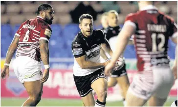  ?? Craig Galloway ?? Forward Lloyd White looks for a way through the Wigan rearguard as Widnes launch another attack.