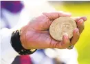  ??  ?? Efrain Santiago holds a replica of the Congressio­nal Medal of Honor awarded to the the 65th Infantry Regiment.