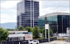  ?? RON SEYMOUR/The Daily Courier ?? The location of a former autobody shop, left, adjacent to one of the Landmark towers reflects the diverse land uses in the area.