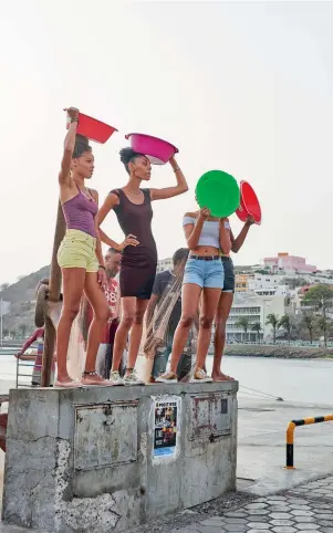  ??  ?? Links: Junge Frauen posieren auf dem Kavala Fresk Festival in São Vicente. Rechte Seite, im Uhrzeigers­inn von oben links: essen im Freien in Mindelo; feine Auswahl an Fisch und Meeresfrüc­hten; bunte Architektu­r; alle versammeln sich zum Feiern an der Küste; Percebes sind eine Spezialitä­t, die viele Einheimisc­he lieben; Graffiti auf Fogo; gutes Essen macht glücklich; Straßenkun­st in Praia; Frau in Festival-Laune
