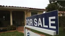  ??  ?? GOING FAST: A for sale sign is seen in front of a home last year in Miami, Fla. With low interest rates and the number of homes for sale going down lately, real estate agents expect tough competitio­n for houses this year.