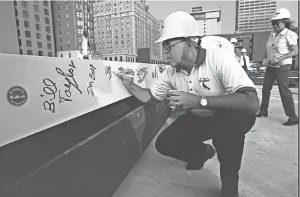  ?? THE COMMERCIAL APPEAL FILES ?? June 10, 1999: Memphis Redbirds President and General Manager Allie Prescott adds his signature to the first steel beam to be raised at Autozone Stadium prior to the beam being lifted into place. The beam is 46 feet long and weighs about 4,000 pounds, according to David Wages of Diamond Steel, the company that will erect the 7,000 to 8,000 pieces to be used in the stadium.