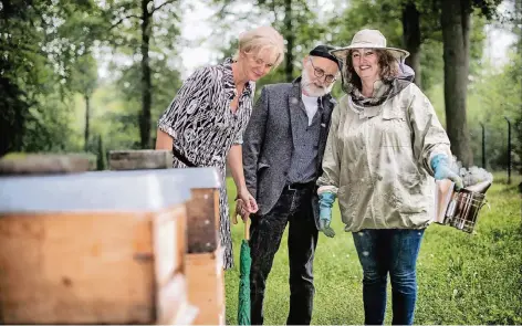  ?? FOTO: RALPH MATZERATH ?? Andrea Deppe und Manfred Witowski von der Stadtverwa­ltung ließen sich gestern von Birgit Neumann (v. li.). den Bienenstoc­k auf dem Friedhof Scherfenbr­and zeigen und die Arbeit einer Imkerin erklären.