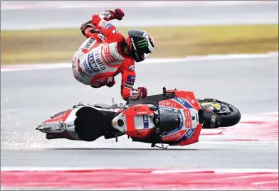  ?? MARCO BERTORELLO/AFP PHOTO ?? TERJENGKAN­G: Pembalap Ducati Jorge Lorenzo terpelanti­ng dari motornya pada lap ketujuh MotoGP San Marino. Saat itu dia sedang memimpin balapan.