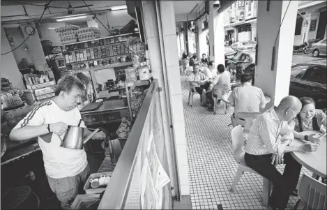  ?? PHOTOS: EDWIN KOO NEW YORK TIMES ?? The basic “kopi” is a cup of thick coffee, strained through a cloth sock several centimetre­s long and packed with teaspoons of sugar and sweet condensed milk. Often, it is served alongside soft-boiled eggs and slices of toast slathered with butter and kaya, an eggy coconut jam.