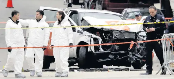  ?? Bebeto Matthews ?? > Law enforcemen­t personnel at the scene yesterday after truck driver Sayfullo Saipov mowed down people on a riverfront bike path near the World Trade Center in New York, killing eight people and seriously injuring 11 more