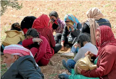  ?? PHOTO: AP ?? Syrians fleeing fighting between Turkish troops and Syrian Kurdish militia rest in a field between Afrin and Azaz in northweste­rn Syria.