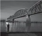  ?? MICHAEL CLEVENGER/COURIER JOURNAL ?? The Big Four pedestrian bridge is lighted in blue and yellow, the colors of Ukraine on Feb. 26, 2022.