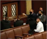  ?? DREW ANGERER — GETTY IMAGES ?? U.S. Capitol police officers point their guns at a door that was vandalized in the House Chamber during a joint session of Congress on Wednesday in Washington, DC.