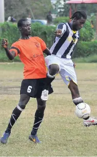  ??  ?? In this file photo from December 2013, Montego Bay Boys’ and Girls Club (MBBGC) striker Androcles Poyser (right) attempts to control the ball while under pressure from Savannah SC defender Shamar Bernard during a Captain’s Bakery and Grill-J.B....