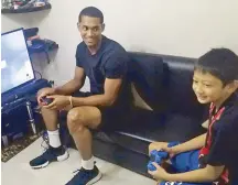  ??  ?? Jordan Clarkson plays a video game with 10- year- old fan Jordan Salandanan during a surprise visit to the Ateneo Small Basketeers point guard’s 37th floor room at the SM Blue Residences on Katipunan.