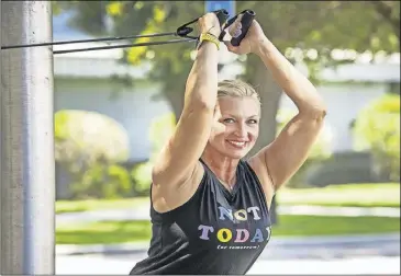  ?? PHOTO ERNST PETERS/THE LEdGER ?? Triceps overhead extensions with band.