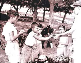  ?? ?? Children buying prickly pears from a vendor during the war famine.