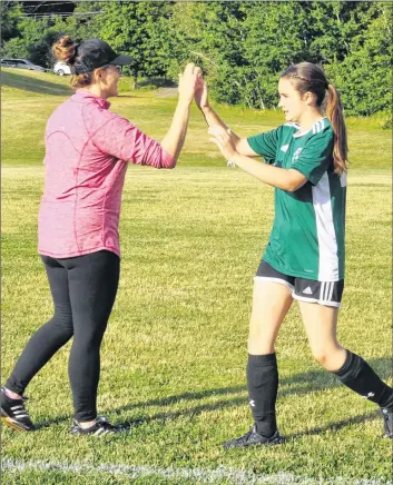  ?? SARA ERICSSON PHOTOS ?? Soccer coach Shelley Peach high fives her daughter and team player, Madison, after the game’s first half drew to a close.