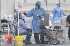  ?? LYNNE SLADKY — THE ASSOCIATED PRESS ?? On Monday, a health care worker administer­s a COVID-19 test at a site sponsored by Community Health of South Florida at the Martin Luther King Jr. Clinica Campesina Health Center in Homestead, Fla.