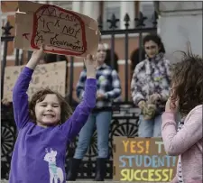  ?? LIBBY O’NEILL — BOSTON HERLAD ?? Jamaica Plain’s six-year-old June Olivetti holds up a homemade sign to help the Massachuse­tts Teachers Associatio­n protest against MCAS in front of the State House.