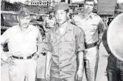  ?? ?? No Kum-Sok, who later became a United States citizen and changed his name to Kenneth Rowe, walks with U.S. military personnel shortly after defecting to South Korea during the Korean War in 1953.