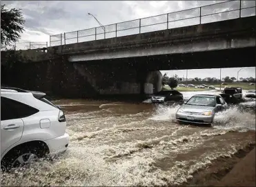  ?? STAFF PHOTO ?? Cars plow through floodwater­s on U.S. 35. The forecast calls for highs in the 60s today, the 70s for Tuesday and Wednesday and maybe even back in the 80s by Thursday and the upcoming weekend.