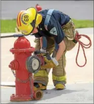  ?? PETE BANNAN — DIGITAL FIRST MEDIA ?? Elijah Romano of Valley Forge Fire Company attaches a hose to the hydrant during Chester County Department of Emergency Services’ Junior Public Safety Camp Olympics Thursday at the Chester County Public Safety Training Campus, Tactical Village in S....