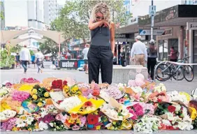  ?? DAVID GRAY AFP VIA GETTY IMAGES ?? A woman leaves flowers outside the Westfield Bondi Junction shopping mall in Sydney on Sunday, a day after a man killed six people, including five women. It seems “terrorism” can only be applied to crimes associated with fanatical religious ideology and white supremacy, Rosie DiManno writes.