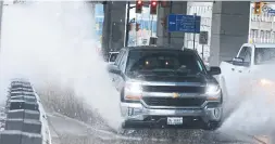  ?? VINCE TALOTTA PHOTOS/TORONTO STAR ?? Vehicles drive through a pool of water on Lake Shore Blvd.