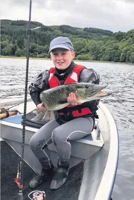  ??  ?? Pike dreams Ruaraidh shows off the fish - before returning it to the loch