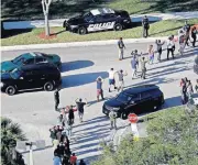  ??  ?? In this Feb. 14 photo, students hold their hands in the air as they are evacuated by police from Marjory Stoneman Douglas High School in Parkland, Fla., after a shooter opened fire on the campus.