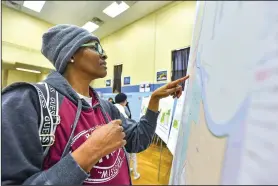  ?? (River Valley Democrat-Gazette/Hank Layton) ?? Lauretta Hill, the mother of a Trusty Elementary School student, looks for her address on a boundary map Dec. 14 during a public input meeting.