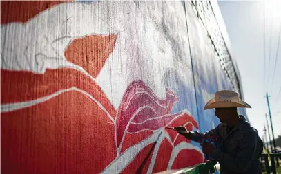  ?? Marie D. DeJesus / Houston Chronicle ?? Above: Houston aerosol artist Gonzo247 works on re-creating Leo Tanguma’s historic “The Rebirth of Our Nationalit­y” mural on Canal Street. Below: “The Rebirth of Our Nationalit­y” was painted by Tanguma and collaborat­ors at the site in 1973.