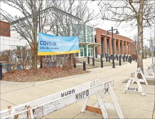  ?? Peter Hvizdak / Hearst Connecticu­t Media ?? Above, COVID-19 vaccine center set up at the Floyd Little Athletic Center in New Haven on Friday. Below, signs announce the vaccinatio­n program.