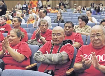  ?? Photog raphs by Anne Cusack Los Angeles Times ?? ACTIVISTS wear shirts bearing the number 24,000 at the Board of Supervisor­s meeting on Tuesday. The number represents county residents who are not receiving treatment for AIDS and HIV, supporters say.