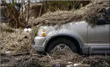  ?? ?? Marsh grass covers a vehicle in Ironton. The entire town is without power and running water since Ida stormed ashore a month ago.
Residents were left without much to salvage.