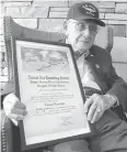  ?? Associated Press ?? ■ World War II veteran Bob Barger poses Wednesday with his Naval flight school certificat­e in Toledo, Ohio.