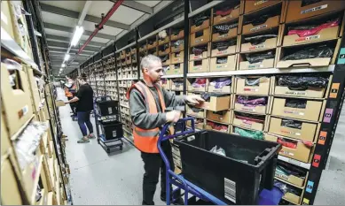  ?? PROVIDED TO CHINA DAILY ?? Amazon employees sort clothing items at the company's fulfillmen­t center in Swansea, the United Kingdom.