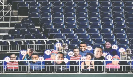  ?? GREG FIUME/GETTY IMAGES ?? Photo cut-outs of the family of Washington Nationals left fielder Juan Soto adorn the left field seats for his season debut against the New York Mets at Nationals Park on Wednesday in Washington, D.C. Soto wanted them behind home plate but was denied by the club.