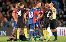  ??  ?? Fernandinh­o of Manchester City goes down injured while City and Crystal Palace players argue with referee Bobby Madley.