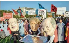  ?? FOTO: KAPPELER/DPA ?? Aktivisten stehen mit Masken vor dem Kanzleramt: Zu sehen sind Wirtschaft­sminister Peter Altmaier, Kanzlerin Angela Merkel und Finanzmini­ster Olaf Scholz.