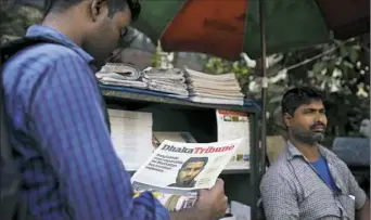  ?? A.M. Ahad/Associated Press ?? A man in Dhaka, Bangladesh, reads a newspaper story on 27-year-old Bangladesh­i man Akayed Ullah, accused of carrying out a bomb attack in New York City’s subway system.