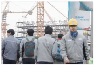  ??  ?? Employees of Daewoo Shipbuildi­ng & Marine Engineerin­g walk in a shipyard in Geoje, South Korea, on Thursday. (Reuters)