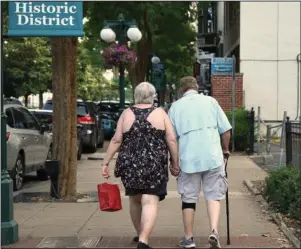  ?? The Sentinel-Record/Cassidy Kendall ?? SHOPPING: Two unidentifi­ed patrons walk hand-in-hand along downtown shops recently.