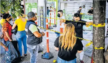  ?? CÉSAR BOLÍVAR ?? Ciudadanos cumplen las normas de biosegurid­ad mientras hacen sus compras en un local del Centro.