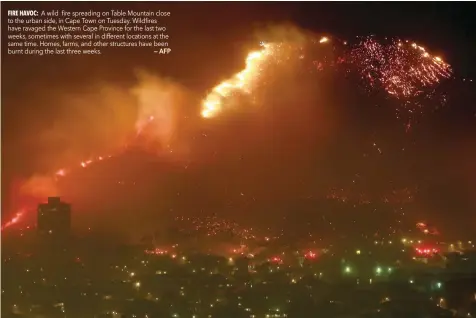  ?? — AFP ?? A wild fire spreading on Table Mountain close to the urban side, in Cape Town on Tuesday. Wildfires have ravaged the Western Cape Province for the last two weeks, sometimes with several in different locations at the same time. Homes, farms, and other structures have been burnt during the last three weeks.