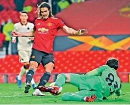  ?? — AFP ?? Manchester United’s Edinson Cavani (left) shoots past Roma goalkeeper Antonio Mirante to score in the Europa League semifinal first leg match at Old Trafford in Manchester on Thursday.